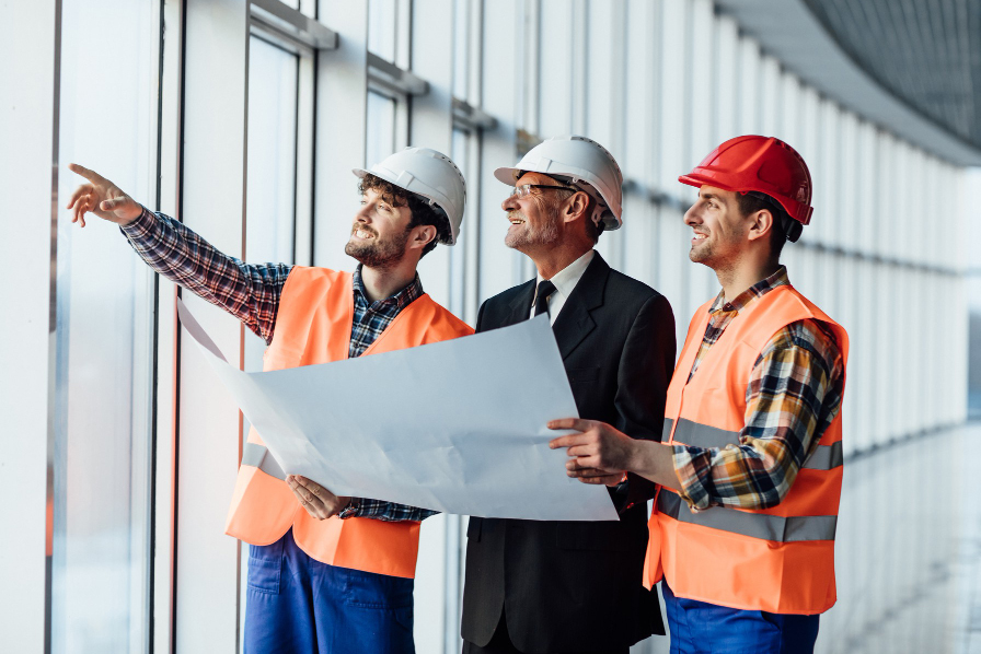 Engineers and construction managers reviewing blueprints on-site, representing recruitment assessments for construction and engineering roles.